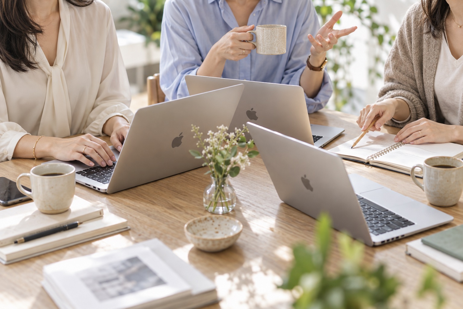 MacBookを囲み、会話やアイデアを交わす女性たちのイメージ